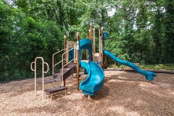 Apartments In Sandy Springs, GA for Rent – Celebration at Sandy Springs -a playground with a blue slide and stairs in a park